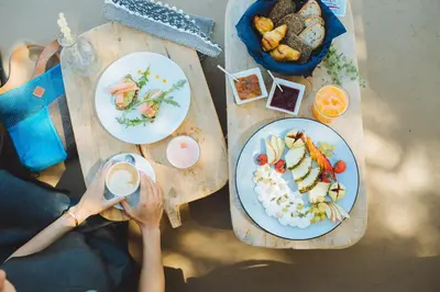 a woman sitting at a table with plates of food at The Theodore Boutique Hotel- adults only 16 plus in Agia Marina Nea Kydonias