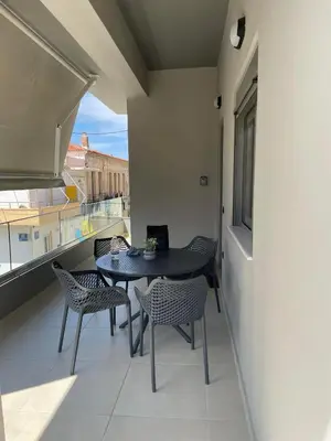 a balcony with a table and chairs and a window at Stefania's House in Chania Town