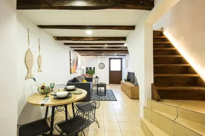 a kitchen and living room with a table and stairs at Splatzia old town maizonette in Chania Town