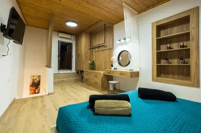 a large bedroom with a blue bed and wooden floors at Splatzia old town maizonette in Chania Town