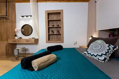 a large blue bed in a room with a mirror at Splatzia old town maizonette in Chania Town
