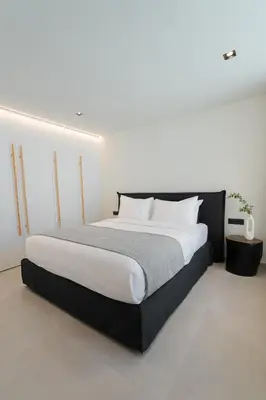 a bedroom with a large bed with white sheets at Hygge Villa Evgenia in Kounoupidhianá