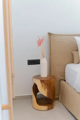 a table with a vase on it next to a bed at Hygge Villa Evgenia in Kounoupidhianá