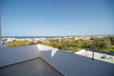 a white balcony with a view of the city at Montis villa sea view heated pool in Daratso