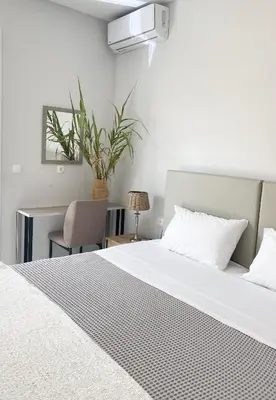 a bedroom with a bed and a desk with a plant at YVONNE's HOUSE in Chania Town