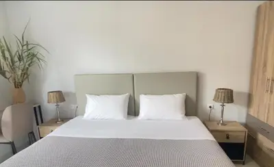 a bedroom with a large white bed with two lamps at YVONNE's HOUSE in Chania Town