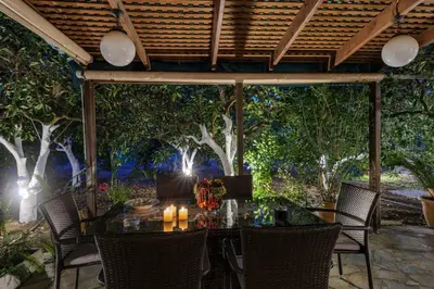 a table and chairs under a pergola with trees at Paradise Lost in Gerani Chanion