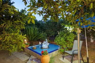 a garden with a fountain in the middle of a yard at Paradise Lost in Gerani Chanion
