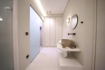 a white bathroom with a sink and a mirror at Amelia Luxury Suites Old Town in Chania Town