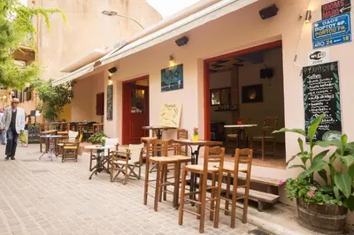 a restaurant with tables and chairs on a sidewalk at Xenon Apartments in Chania Town