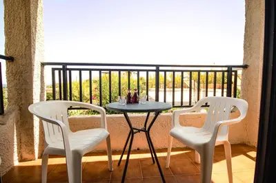 two chairs and a table on a balcony at Andy's Gardens in Gerani Chanion