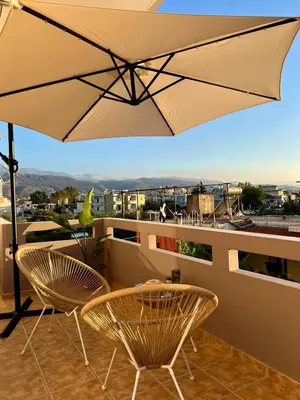 a patio with two chairs and an umbrella at Stratos Apartment in Chania Town
