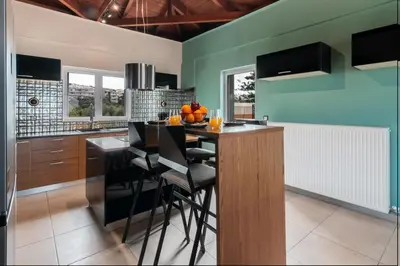 a kitchen with a table and chairs in a room at Alpha delight apartment 3 bedroom in Chania Town