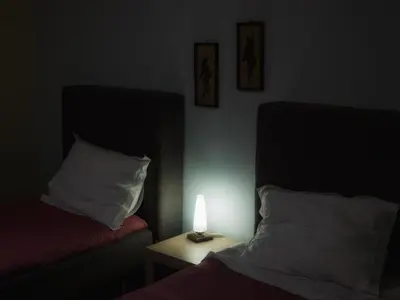 a dark room with a bed and a lamp on a table at Pentari-Bitsakis House in Chania Town