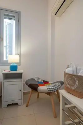 a room with a chair and a table at s - plazza residence in Chania Town