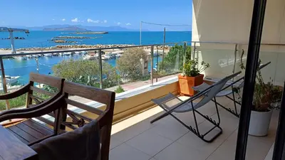 a balcony with a table and chairs and a view of the ocean at Ferienwohnung am Meer Belle Vue in Chania Town