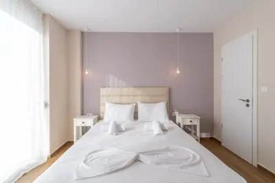 a bedroom with a white bed with a bow tie on it at Odyssey Residences in Chania Town