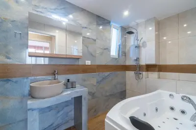 a bathroom with a tub and a sink at Odyssey Residences in Chania Town