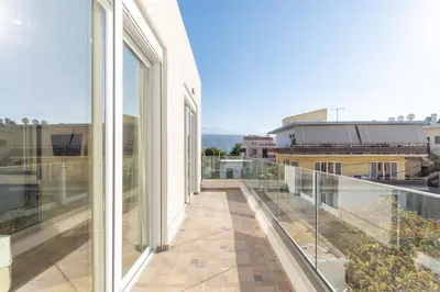 a balcony with glass doors and a view of a city at Odyssey Residences in Chania Town