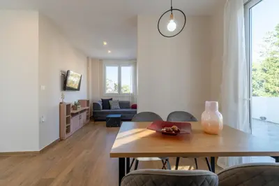a living room with a wooden table and chairs at Odyssey Residences in Chania Town