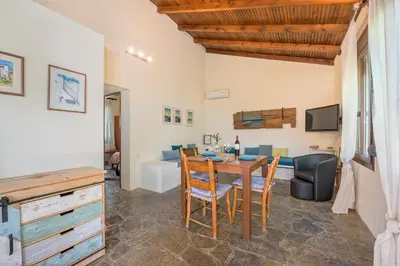 a dining room and living room with a table and chairs at Yiannis Cottage in Spiliá
