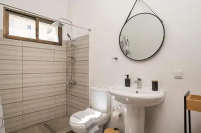 a bathroom with a toilet and a sink and a mirror at Lion's Yard in Chania Town