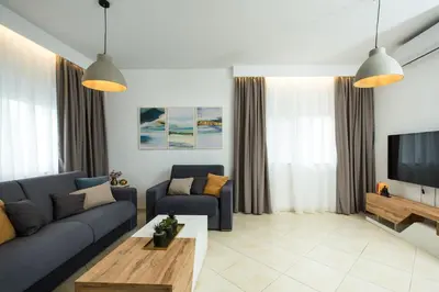 a living room with a couch and a tv at Kiss-ammos Apartments in Kissamos