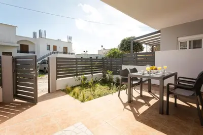 a patio with a table and chairs on a balcony at Kiss-ammos Apartments in Kissamos