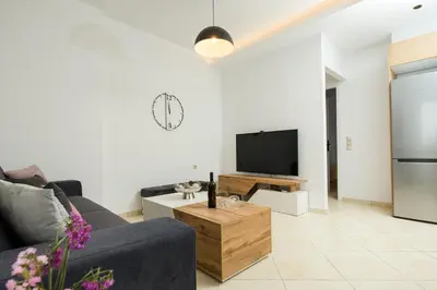 a living room with a couch and a tv at Kiss-ammos Apartments in Kissamos
