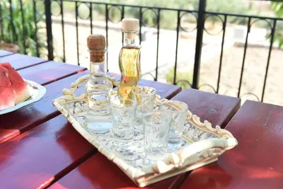 a bottle and glasses on a tray on a table at apartment irini in Vryses