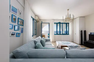 a living room with a blue couch and a chandelier at Villa Chryssi in Tersanas