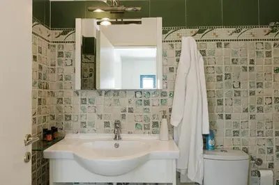 a bathroom with a sink and a mirror and a toilet at Villa Chryssi in Tersanas