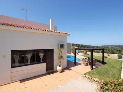 a white house with a patio and a swimming pool at Villa Bellissima in Chania Town