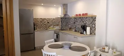 a small kitchen with a white table and a table and chairs at Boschini Loft Life in Chania Town