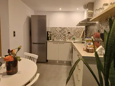a kitchen with a table and a refrigerator at Boschini Loft Life in Chania Town