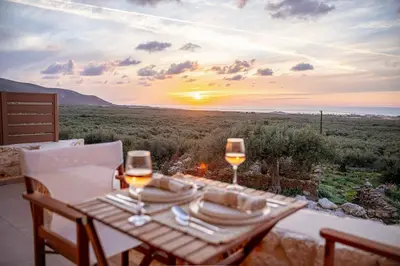 a table with two glasses of wine with a view at Athali Luxury Pocket Villa Stunning Sea View in Falasarna