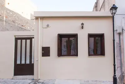 a white building with two windows and a door at Kalliston City House with a Yard in Chania Town