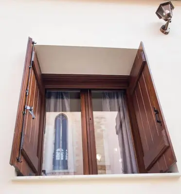 a window on a wall with a tower in it at Kalliston City House with a Yard in Chania Town