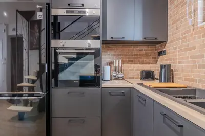 a kitchen with a stainless steel refrigerator and a sink at MOS Luxury Suits 