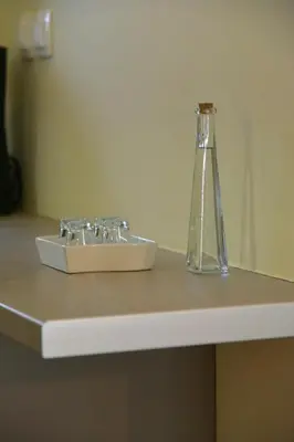 a glass bottle sitting on top of a bathroom sink at Madrugada in Chania Town