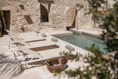 a group of white lounge chairs next to a pool at Corte Interna, free heated pool in Kalivianí