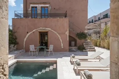 a house with a pool and a table and chairs at Corte Interna, free heated pool in Kalivianí