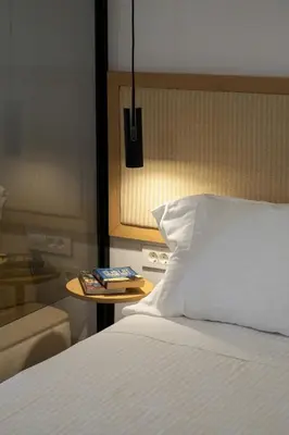 a bedroom with a bed and a table with a book at Studio Verde Glaros w. Outdoors, near the Beach in Kato Daratso