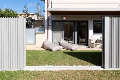 a house with two pillows sitting on the grass at Studio Verde Glaros w. Outdoors, near the Beach in Kato Daratso