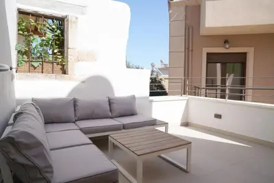 a couch and a coffee table on a balcony at Mystiko Maisonette with Hot Tub - Chania Old Town in Chania Town