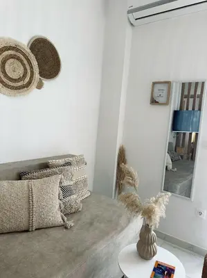 a living room with a mirror and a table at Serenity Living in Palaiochóra