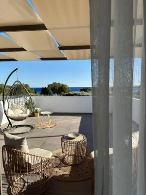 a patio with wicker chairs and a swing at Serenity Living in Palaiochóra