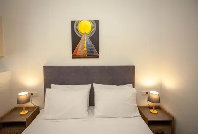 a bedroom with a bed with two lamps and a clock at AZOGIRE Resort in Azoyirés