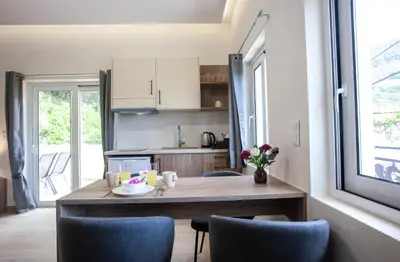 a small kitchen with a wooden table and chairs at AZOGIRE Resort in Azoyirés