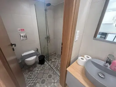 a bathroom with a shower and a toilet and a sink at AZOGIRE Resort in Azoyirés
